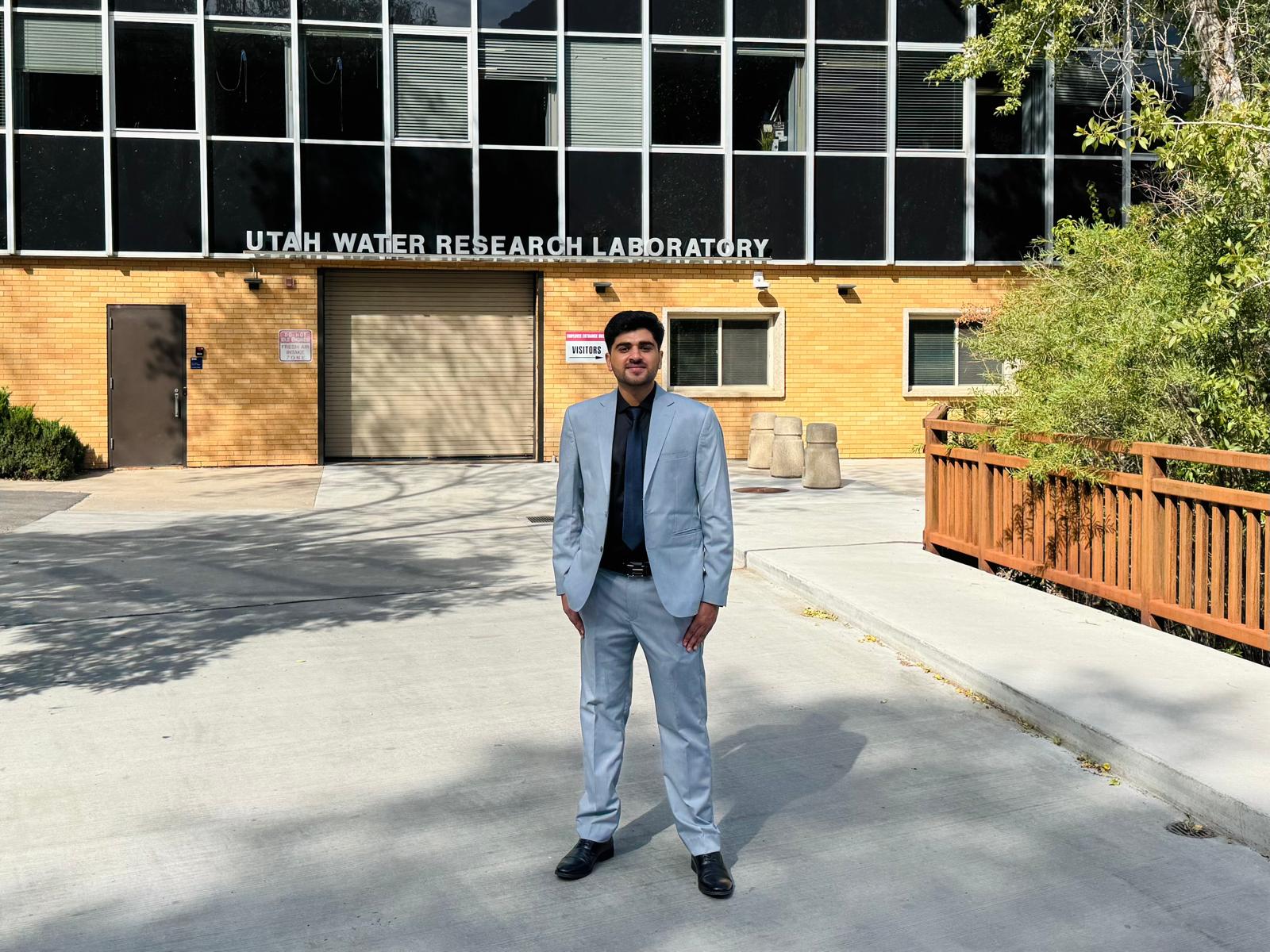 Safran Khan standing in front of the Utah Water Research Laboratory after his comprehensive exam